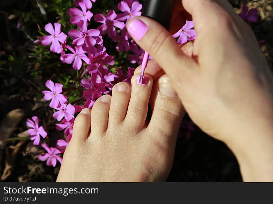 Beautiful Feet ready to be painted with pink nail-polish on a bed of flowers. Beautiful Feet ready to be painted with pink nail-polish on a bed of flowers.