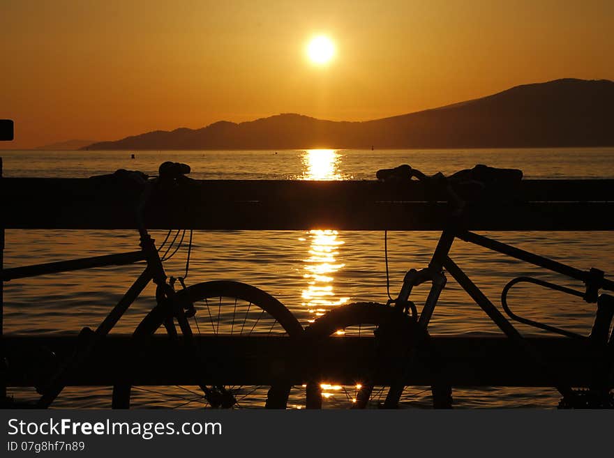 Vancouver Bay sunset with two bicycles in foreground. Vancouver Bay sunset with two bicycles in foreground