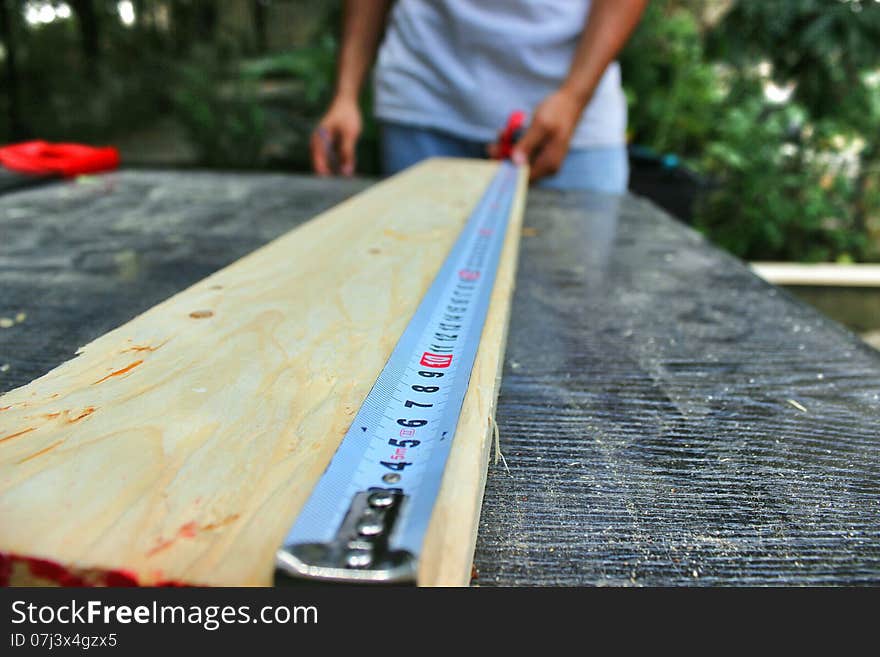 A hard tape used for measuring a wood plank. A hard tape used for measuring a wood plank.