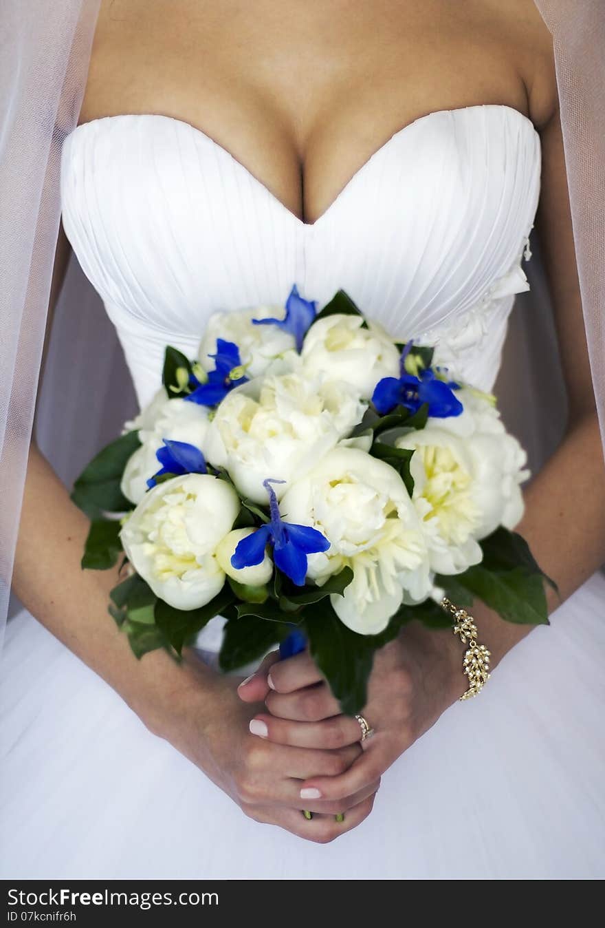 Hands of a bride with a bouquet