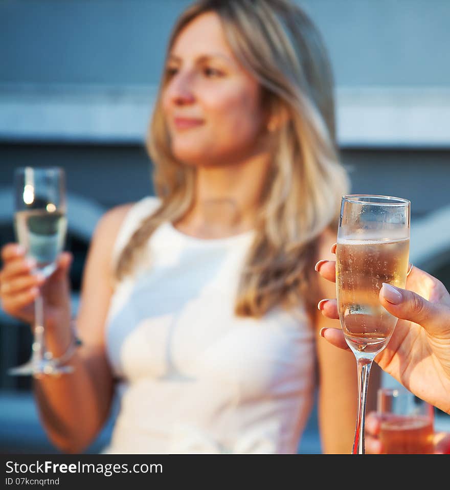 Female hand holding a glass of champagne at a party