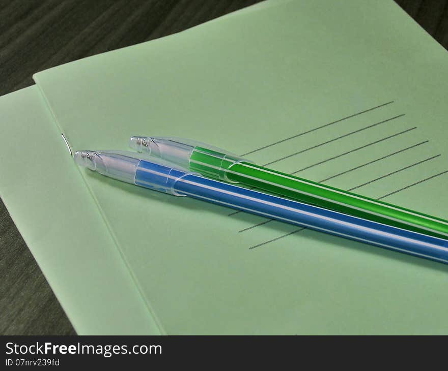 Back to school concept. Thin green notebooks with two handles on the table