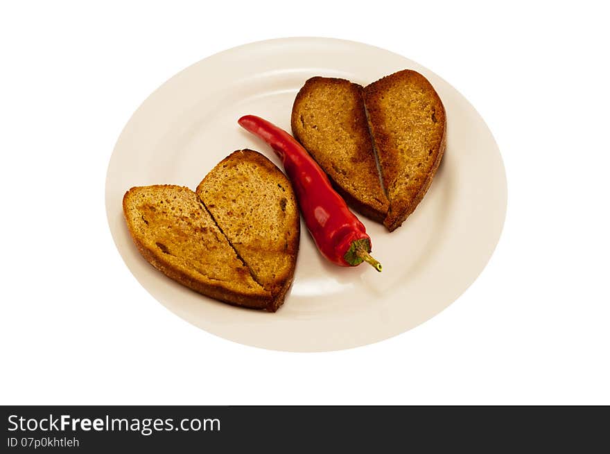 Hot red pepper on a white plate with two heart-shaped toast. Hot red pepper on a white plate with two heart-shaped toast