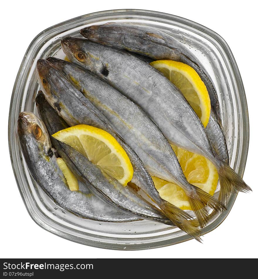 Selar kuning fish with slices of lemon in a transparent glass bowl isolated on white background