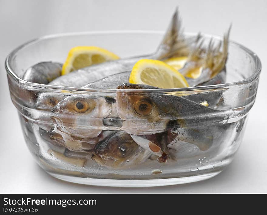 Selar kuning fish with slices of lemon in a transparent glass bowl