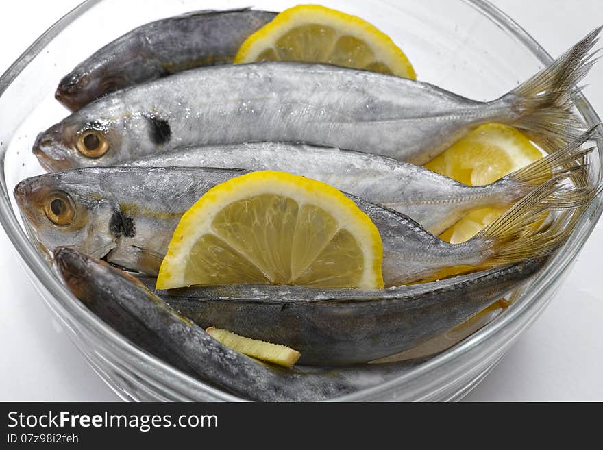 Selar kuning fish with slices of lemon in a transparent glass bowl