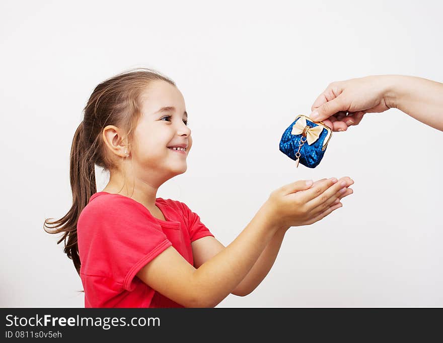 Mother gives the purse to a little girl at home