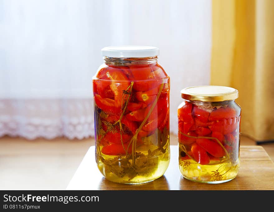 Two glass jars with marinated tomatoes homemade on the table