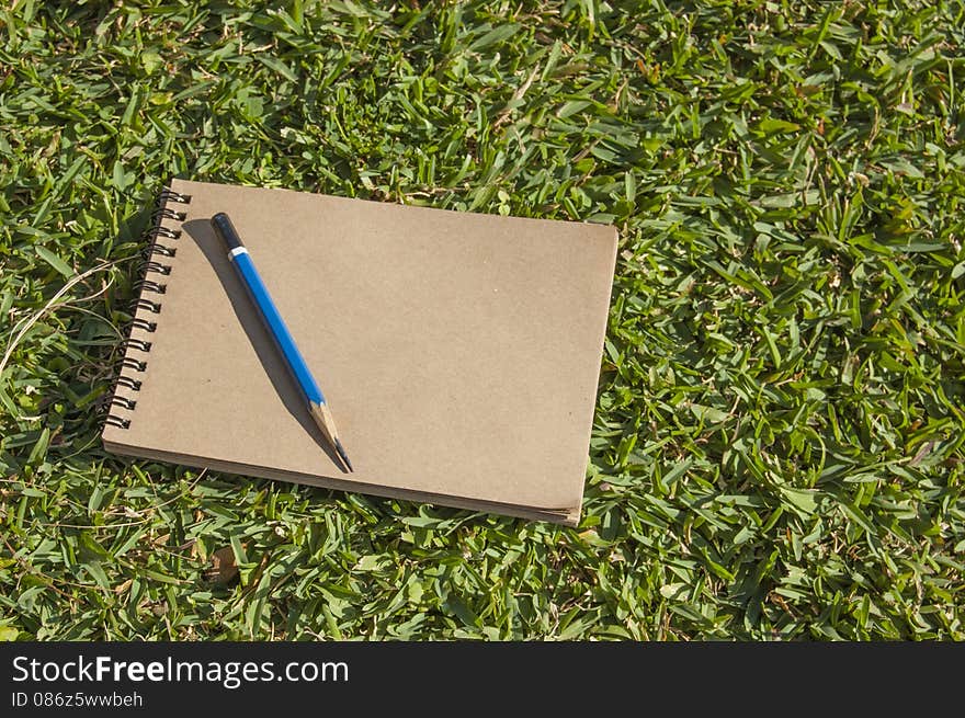 Notebook Lying On Green Grass