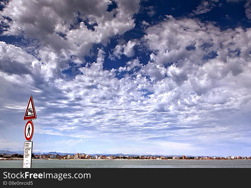 Blue cloudly sky, road sign amd sea. Blue cloudly sky, road sign amd sea