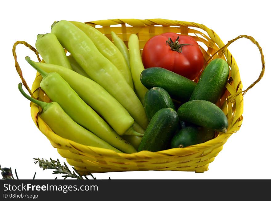 Green peppers, tomato and cucumbers in a basket isolated on white background. Green peppers, tomato and cucumbers in a basket isolated on white background