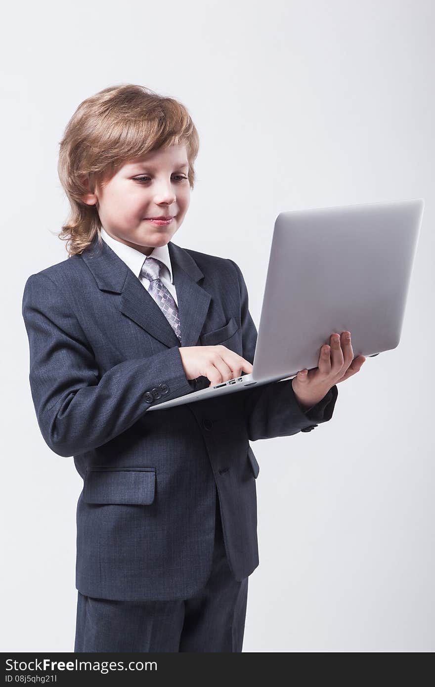 An ambitious young man in shirt and tie with a laptop and looking at the camera