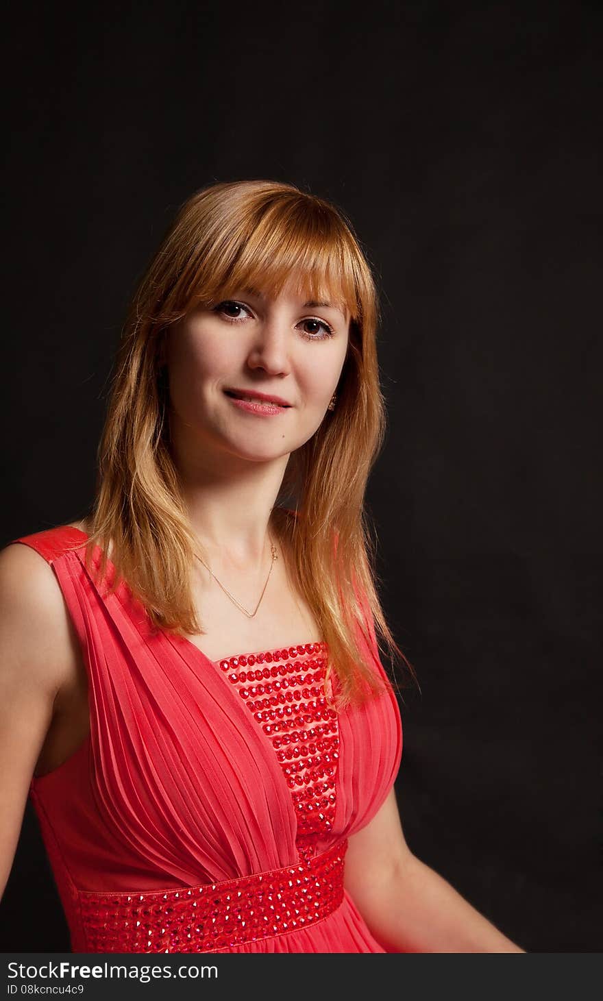 Portrait of a beautiful young woman in a red dress