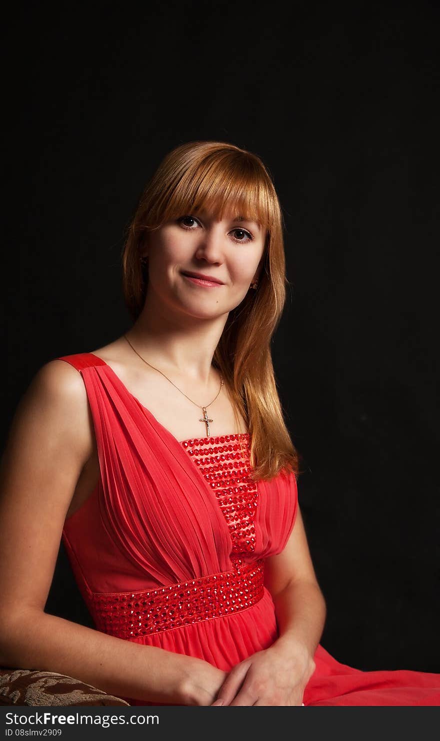 Portrait of a beautiful young woman in a red dress