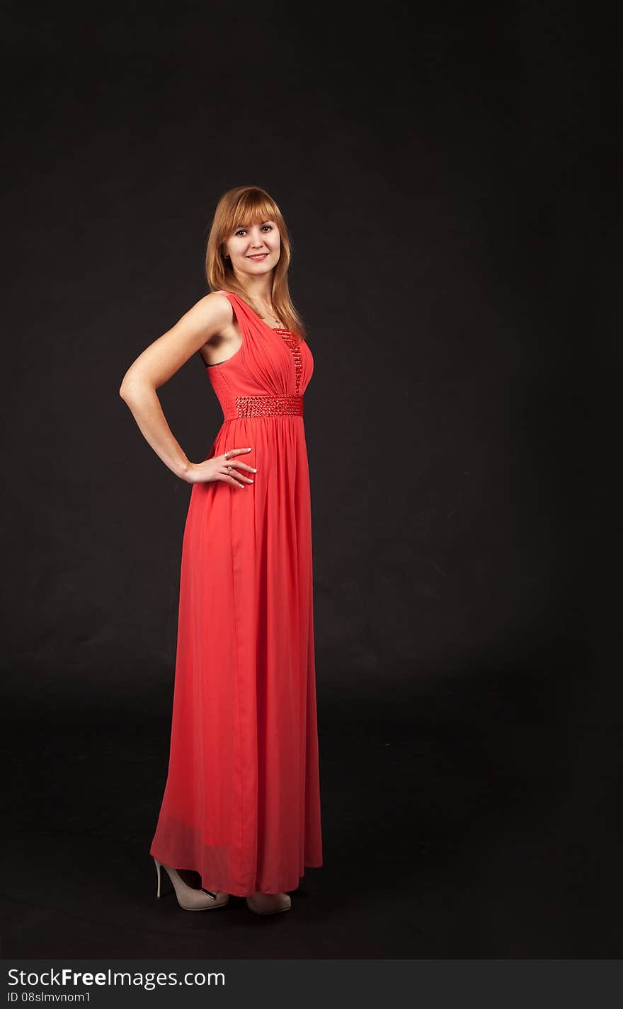 Young beautiful woman in red dress posing standing