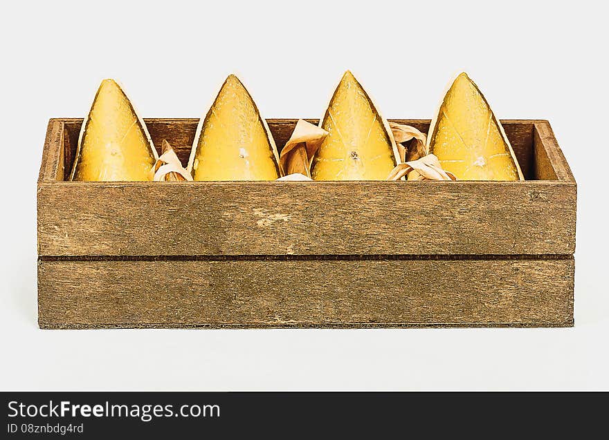 Gift set of 4 decorative candles in the form of lime segments in a wooden box on a white background. Gift set of 4 decorative candles in the form of lime segments in a wooden box on a white background.