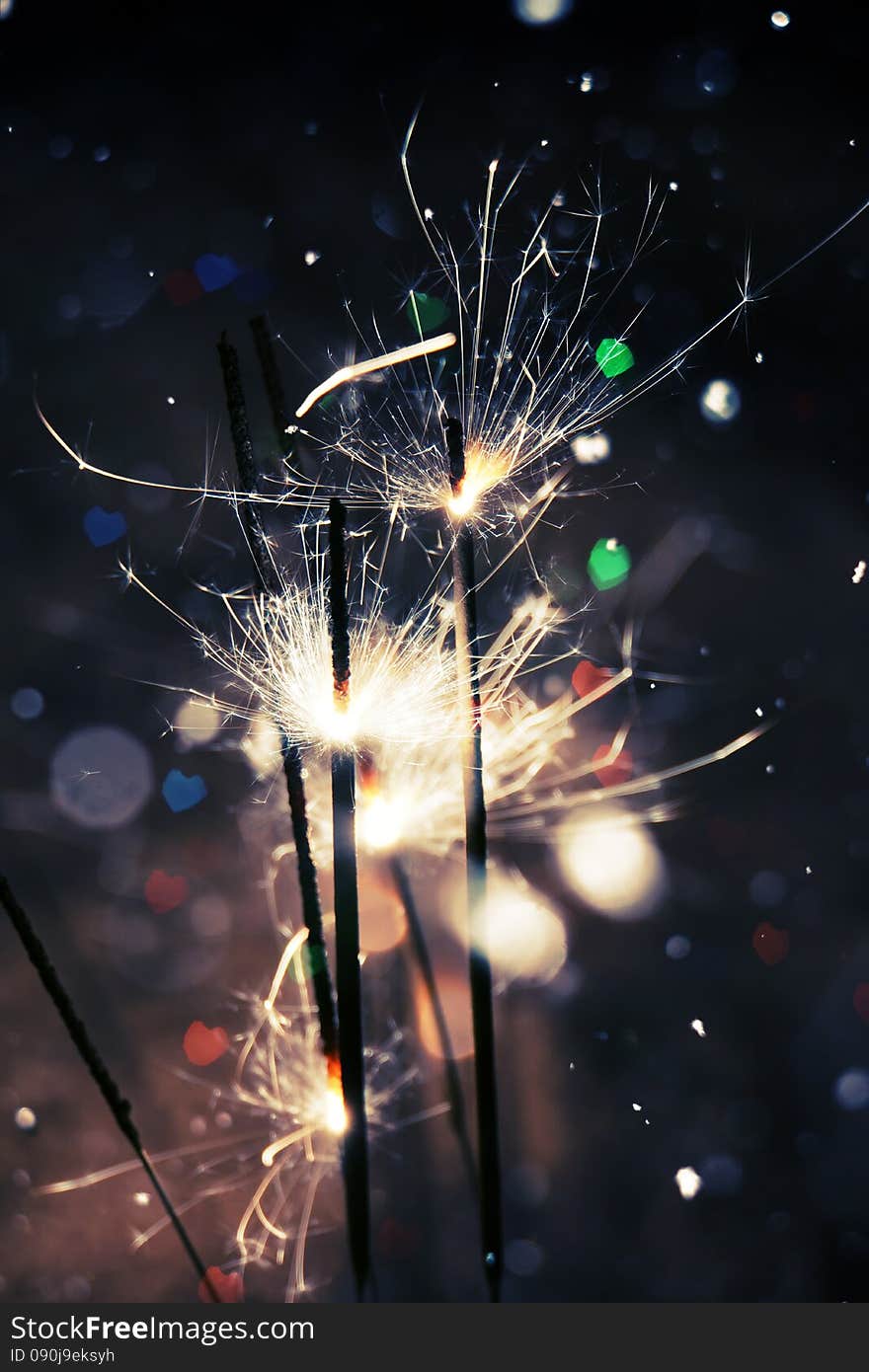 Bengal fire, sparkler and colorful bokeh in a shape of a heart, holiday background. Bengal fire, sparkler and colorful bokeh in a shape of a heart, holiday background.