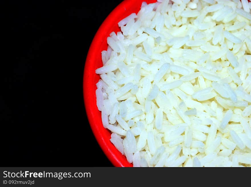 White rice on red plate with black background. White rice on red plate with black background.