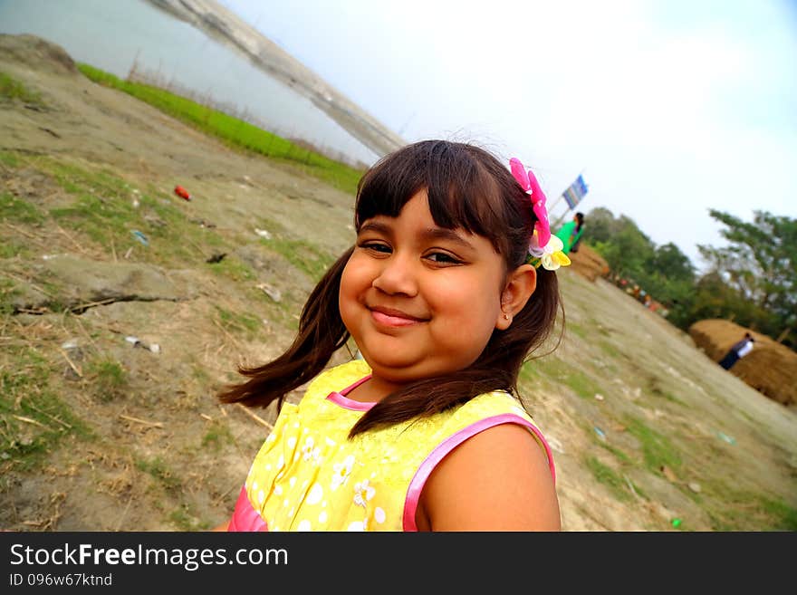 Little Girl Smiling and playing in river bank