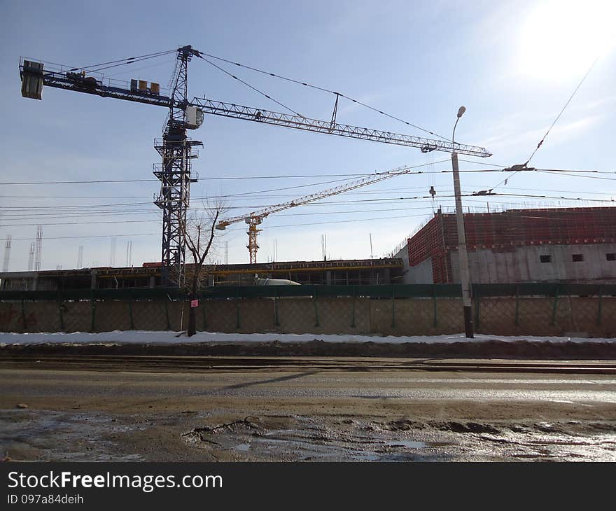 Construction crane working at a height of several tens of meters above the ground. Construction crane working at a height of several tens of meters above the ground.