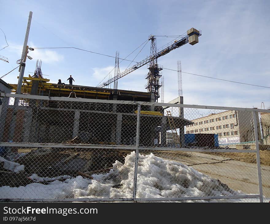 Construction crane working at a height of several tens of meters above the ground. Construction crane working at a height of several tens of meters above the ground.