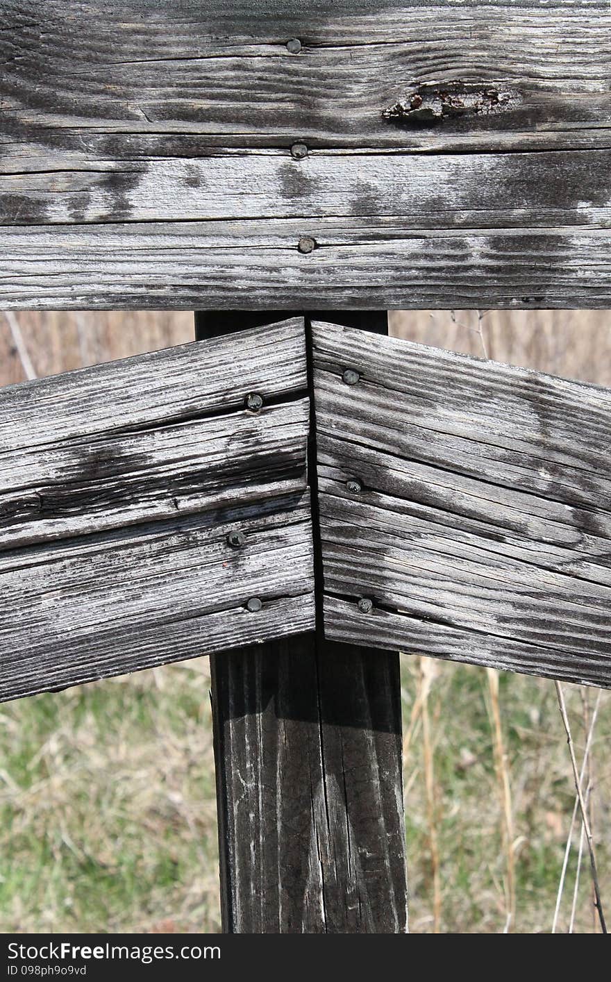 Old weathered country fence made from repurposed wood. Shown with field in the background. Old weathered country fence made from repurposed wood. Shown with field in the background.