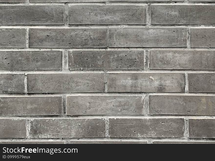 Close-up of the small black bricks in the wall of a building,a good the background source material.