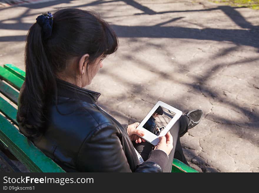 Young Beautiful Woman Looking At A Photo On The Tablet