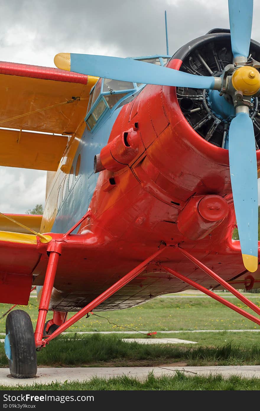 Front view of an old red double-decker airplane standing on the ground