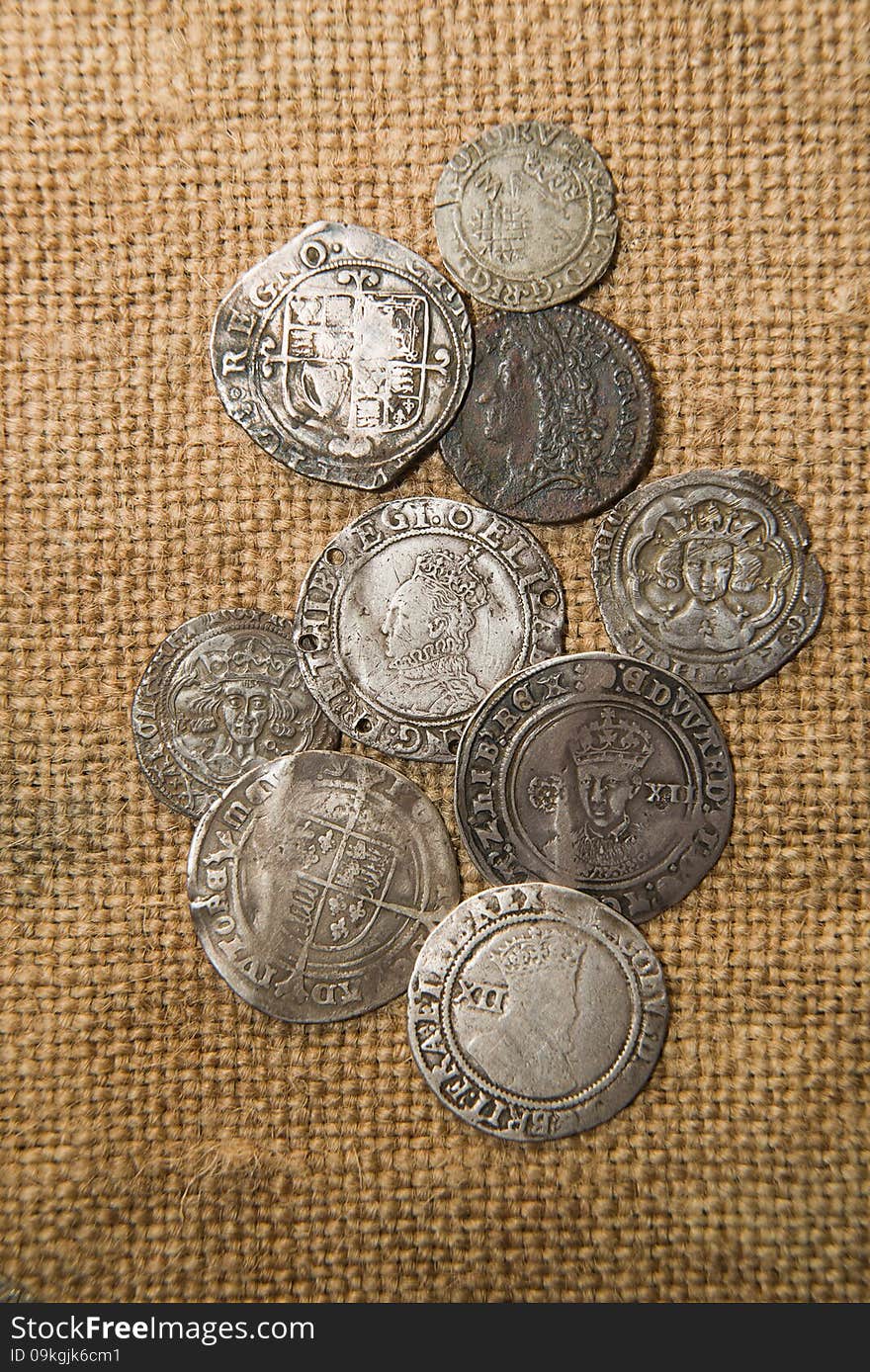 Ancient silver coins with portraits of kings on the old cloth