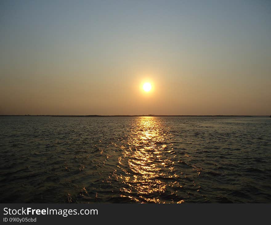 Sunset enveloped the river by the end of the passing day. Sunset enveloped the river by the end of the passing day.