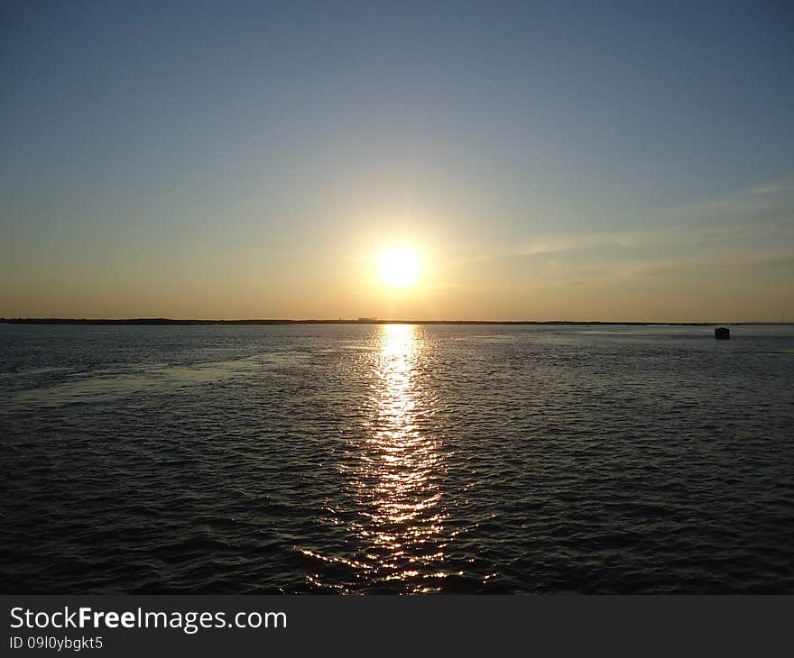 Sunset enveloped the river by the end of the passing day. Sunset enveloped the river by the end of the passing day.