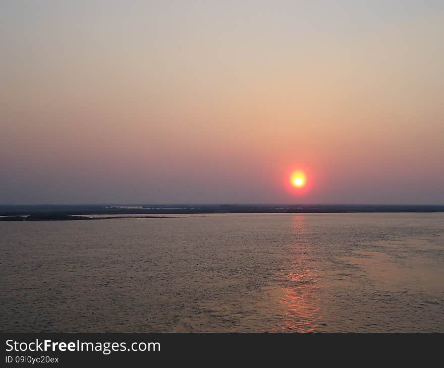 Sunset enveloped the river by the end of the passing day. Sunset enveloped the river by the end of the passing day.