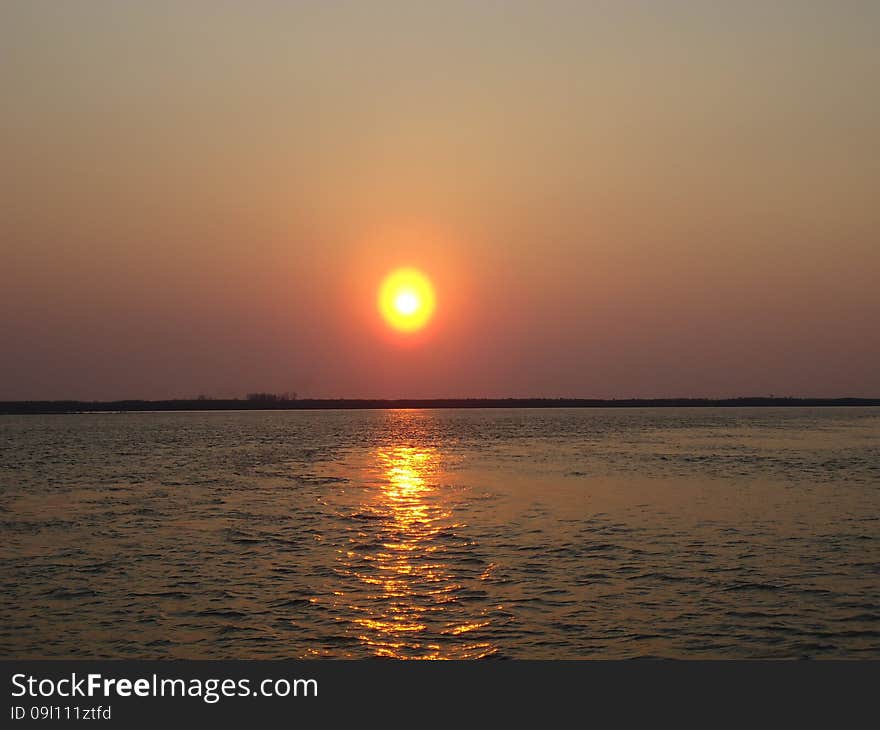 Sunset enveloped the river by the end of the passing day. Sunset enveloped the river by the end of the passing day.