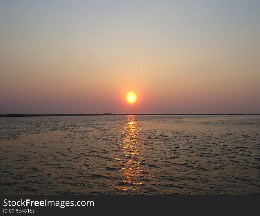 Sunset enveloped the river by the end of the passing day. Sunset enveloped the river by the end of the passing day.