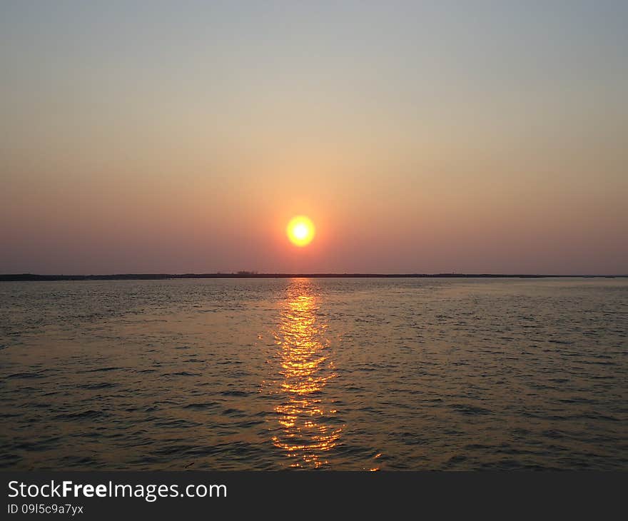 Sunset enveloped the river by the end of the passing day. Sunset enveloped the river by the end of the passing day.