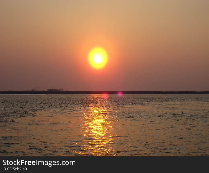 Sunset enveloped the river by the end of the passing day. Sunset enveloped the river by the end of the passing day.