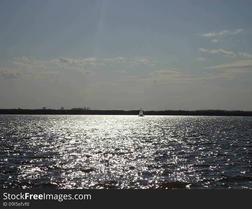 Sailboat floats alone on vast expanses of the river. Sailboat floats alone on vast expanses of the river.