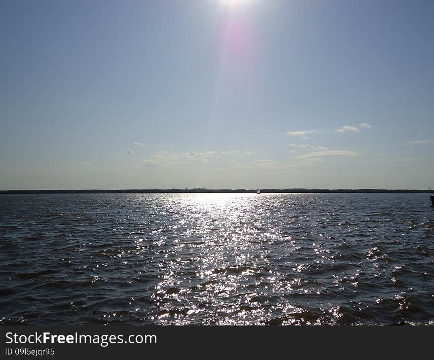 Sailboat floats alone on vast expanses of the river. Sailboat floats alone on vast expanses of the river.