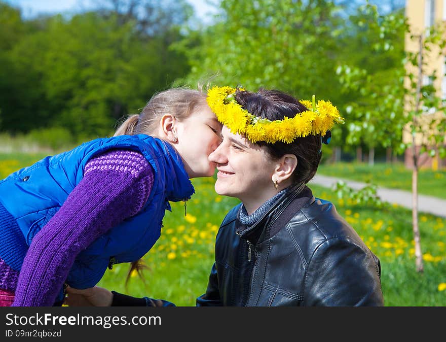 Daughter kisses mom in the park