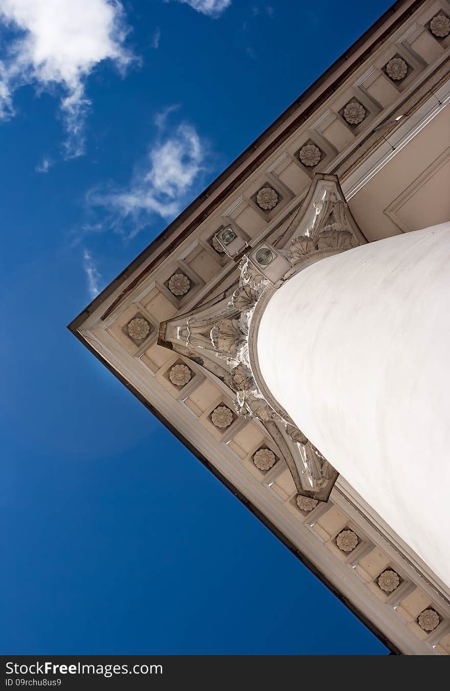 White column and a fragment of the roof of the old building. bottom view