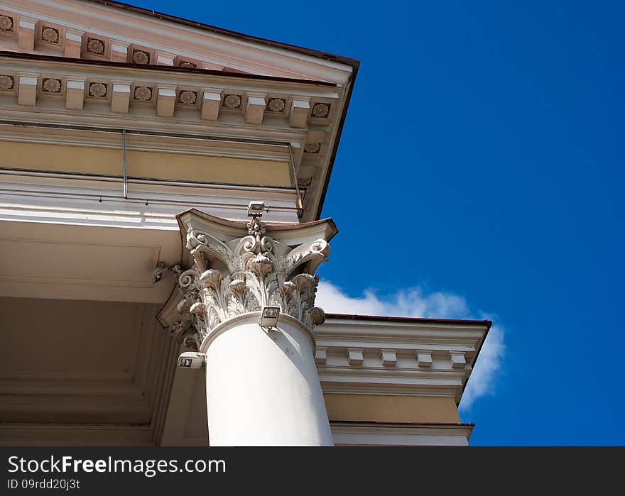 White column and a fragment of the roof of the old building. bottom view, detail