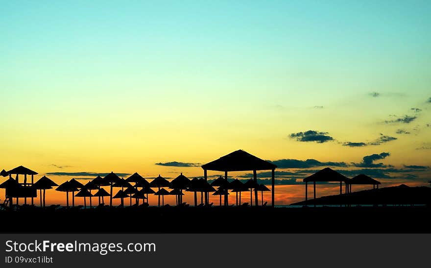 Silhouettes of beach umbrellas on the seashore at