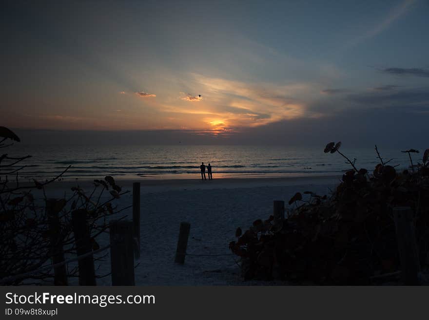 A couple stand in awe of the wonder of the sunset on a Florida Beach. A couple stand in awe of the wonder of the sunset on a Florida Beach