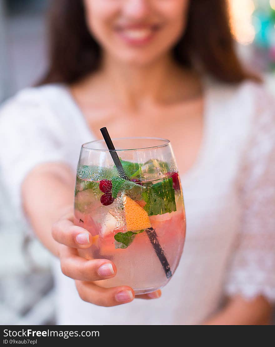 Beautiful smiling woman drinking cold lemonade berry, outdoor