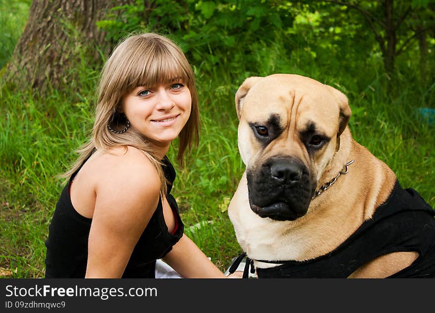 Beautiful young blond woman in a black shirt with her dog in the park. Beautiful young blond woman in a black shirt with her dog in the park