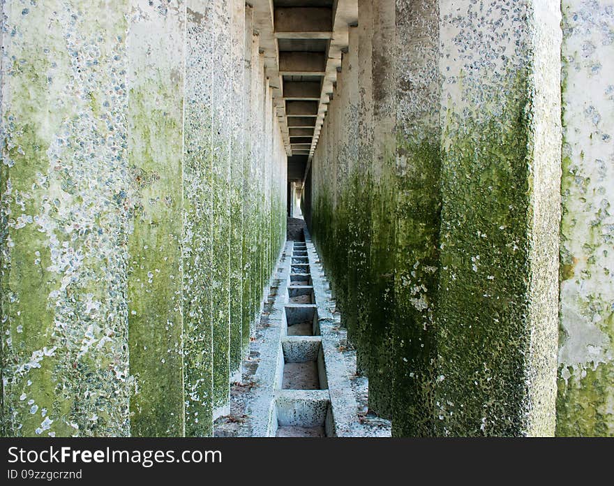 Corridor of old colored concrete pillars with perspective depth closeup