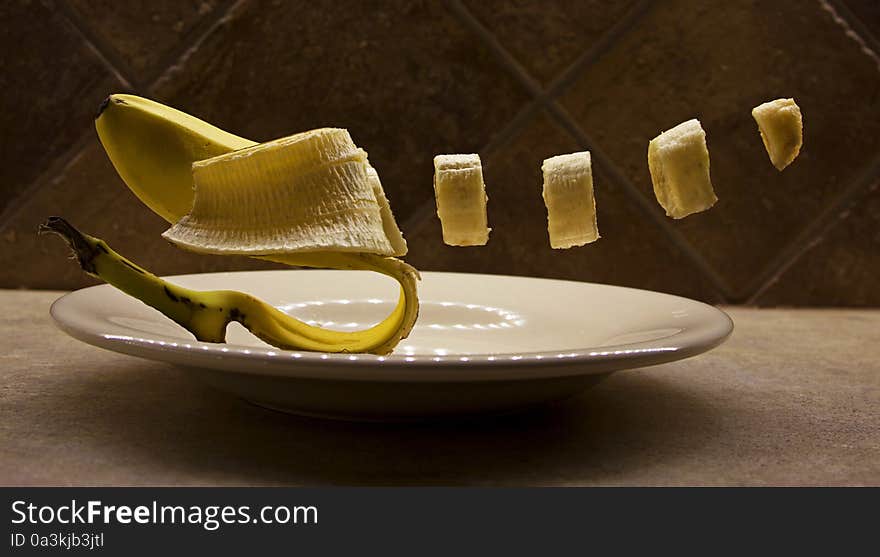 A sliced banana levitating above a plate. A sliced banana levitating above a plate