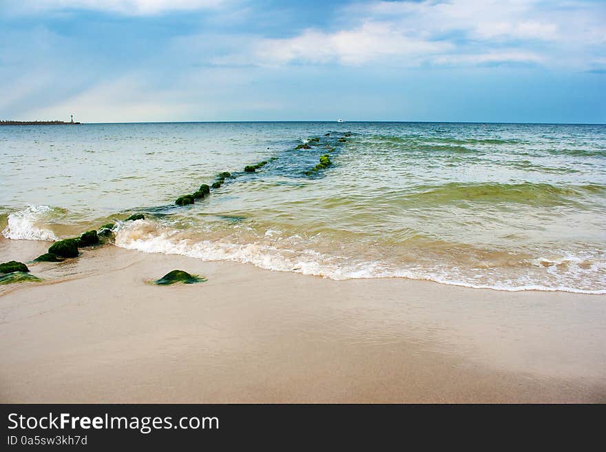 Beach with breakwater on sunny summer day