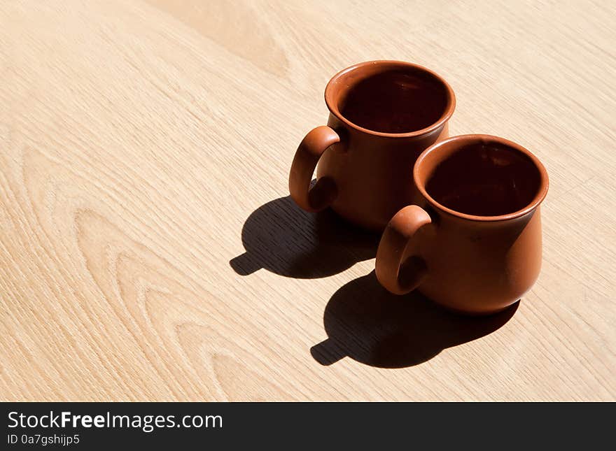 Two clay steins are standing on the floor